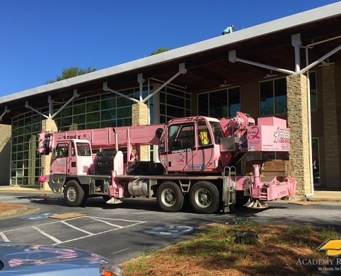Commercial re-roofing in progress with crane on site