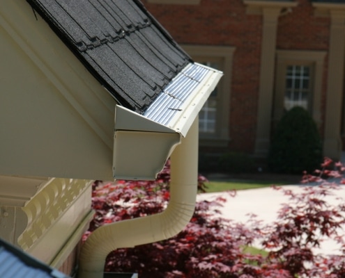 Half round gutters with decorative downspouts on home exterior
