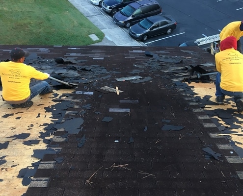 Mid-repair asphalt shingle roofing with underlayment exposed