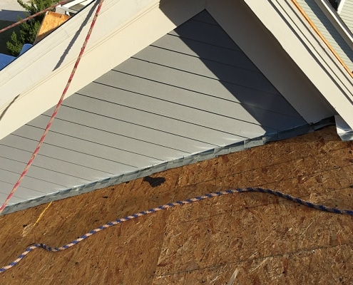 Ongoing roof repair with flashing replacement on sloped roof