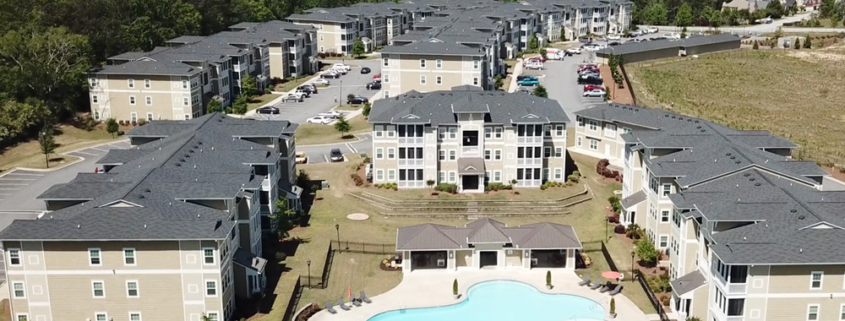 Aerial view of a large apartment complex in Atlanta, GA with well-maintained commercial roofing and a swimming pool